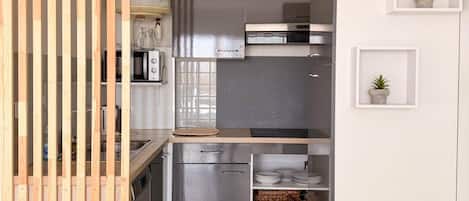 A modern kitchen with a wooden partition, stainless steel appliances, and minimalist decor.