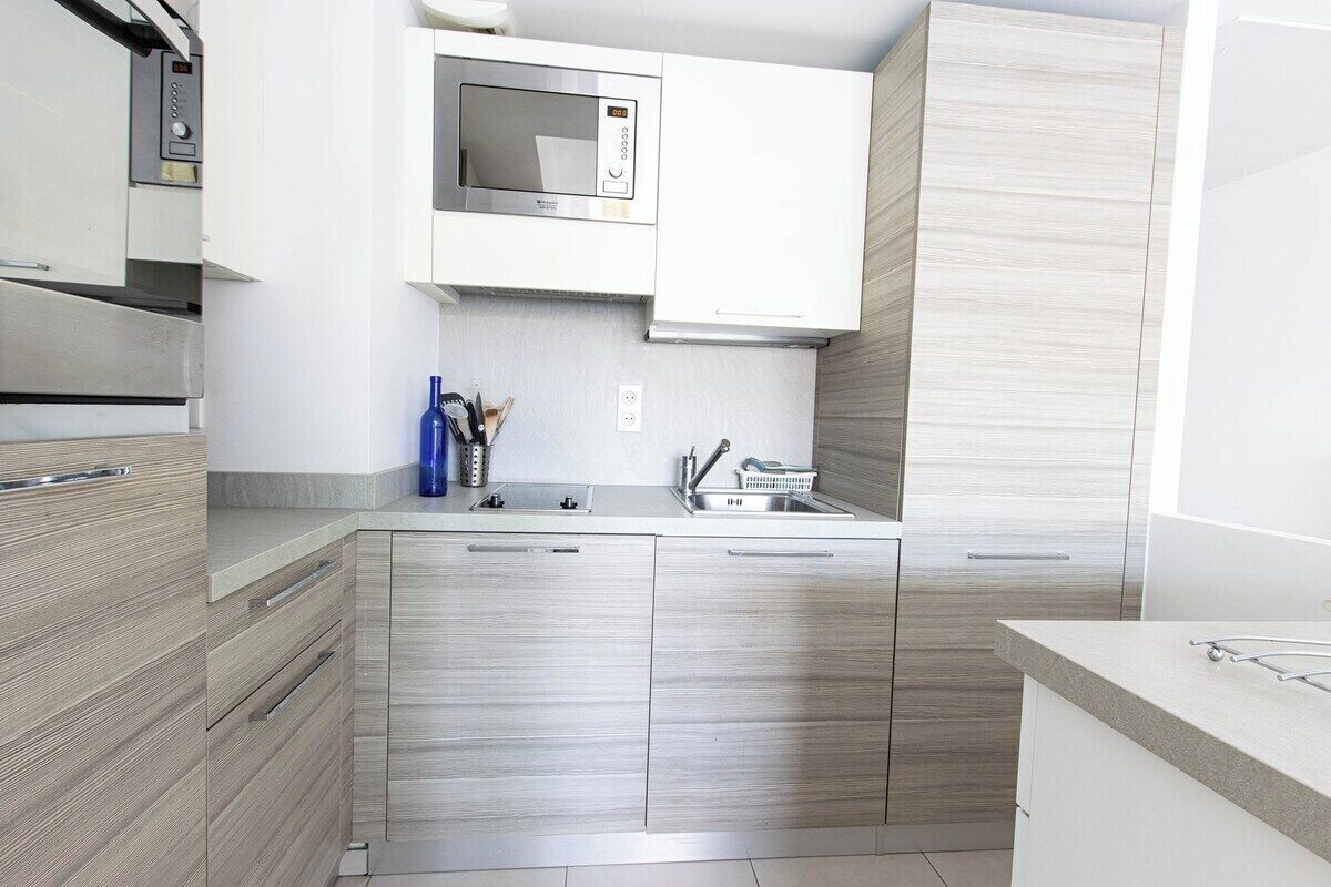 A modern kitchen with stainless steel appliances, a microwave, and a sink.