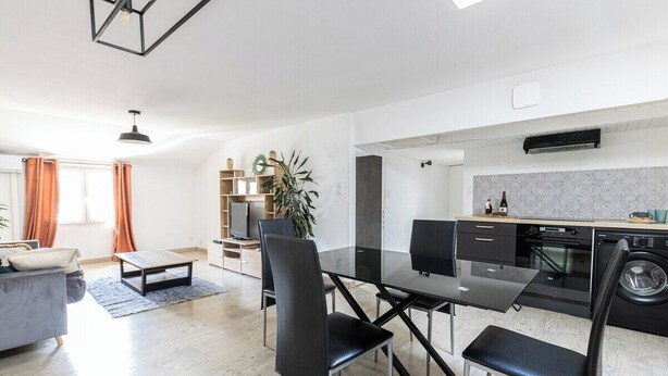Una cocina moderna con comedor, un sofá y una televisión.
