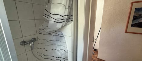 Een douche, handdoeken, toiletpapier