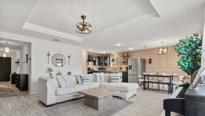 Een moderne woonkamer met een witte bank, een salontafel en een piano.