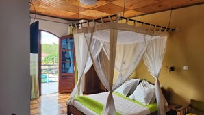 A room with a bed under a canopy, a wooden ceiling, and a view of the outdoors. - MANGORO HOTEL (Moramanga)