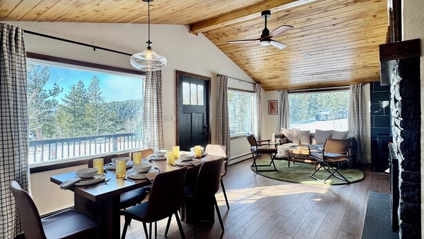 A spacious dining area with a wooden ceiling and large windows offering a view of the outdoors.