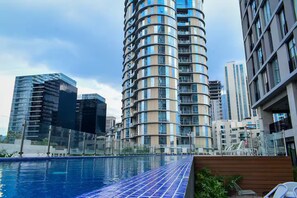 A modern high-rise building with a curved facade and a swimming pool in the foreground. - Skyline Apartment @ Dana Arboleda in San Pedro (San Pedro Garza García)