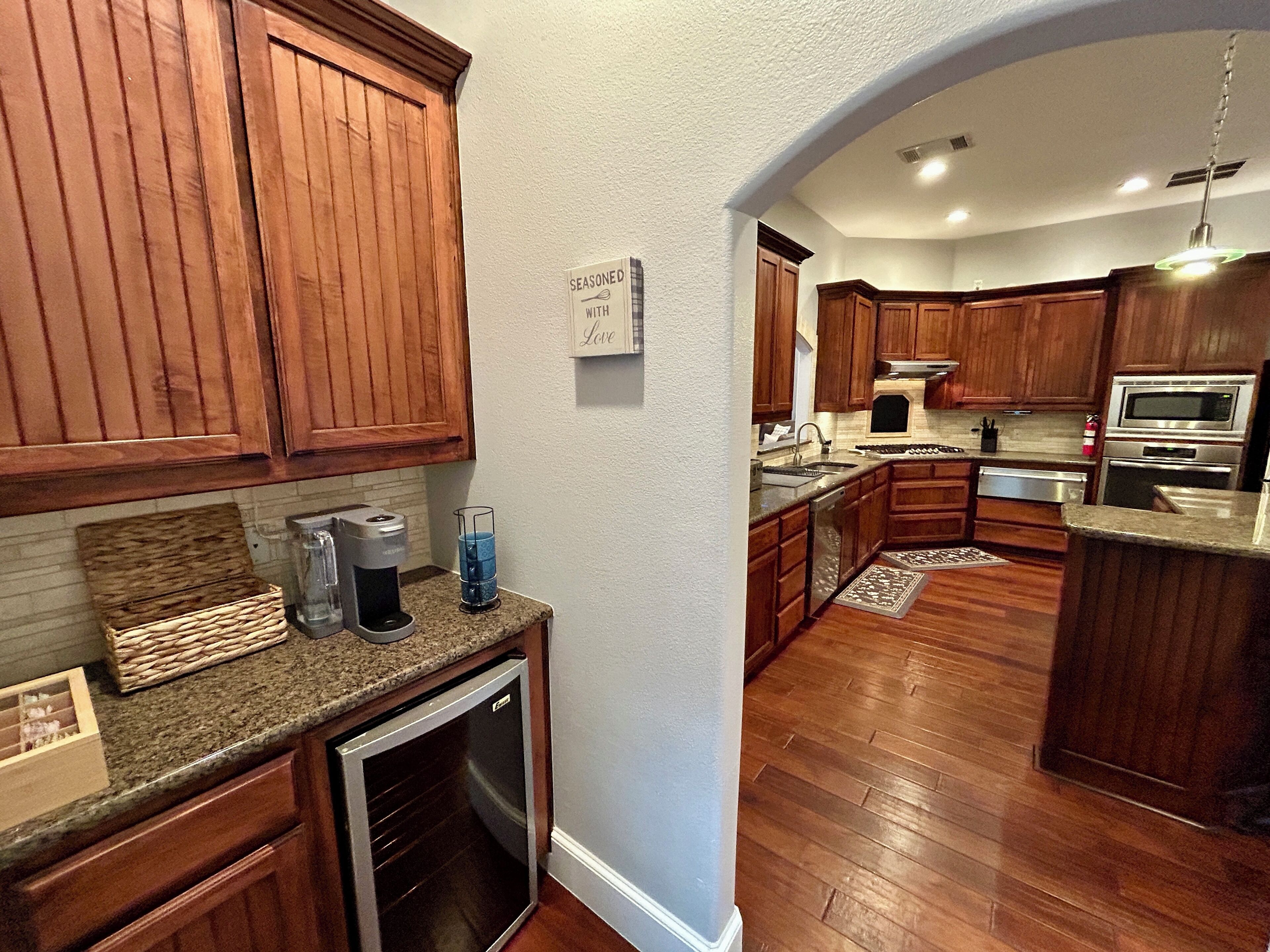 A kitchen with wooden cabinets, a built-in oven, and a coffee maker.