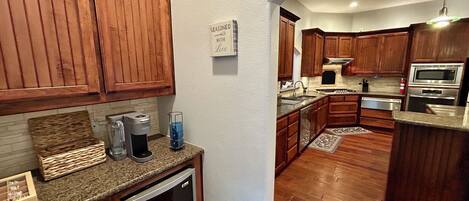 A kitchen with wooden cabinets, a built-in oven, and a coffee maker.