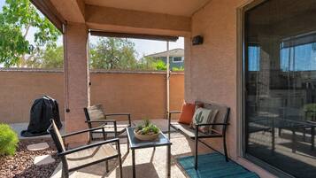 Un patio abrité avec une table, des chaises et une petite plante servant de décoration centrale.