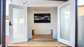 An open door leading to a room with a mounted screen displaying various streaming services. - Spacious 5BD with Pool Table (North Las Vegas)