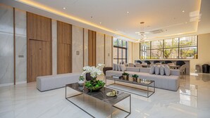 Una sala de estar moderna con un sofá, dos mesas auxiliares y una decoración vegetal.