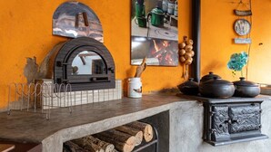 A kitchen with a wood-burning stove, a hanging mirror, and a tiled backsplash. - Casa com fogão a lenha para 7 | Vale das Videiras (Itaipava, Petropolis)