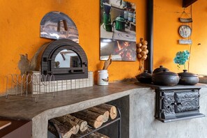 A kitchen with a wood-burning stove, a hanging mirror, and a tiled backsplash. - Casa com fogão a lenha para 7 | Vale das Videiras (Itaipava, Petropolis)