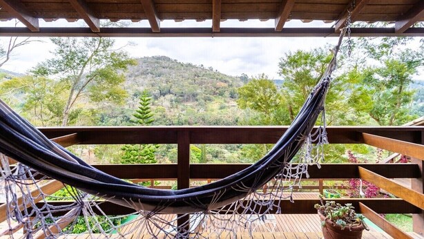 A hammock on a wooden deck with a view of a forested hillside. - Casa com fogão a lenha para 7 | Vale das Videiras (Itaipava, Petropolis)