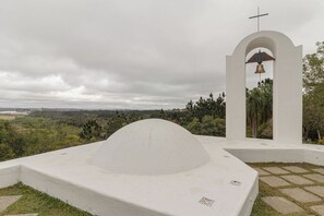 Eine weiße Kirche mit einem Glockenturm und einer kuppelförmigen Struktur im Vordergrund.