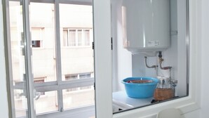 A kitchen with a window, a blue bowl, and a wooden table.