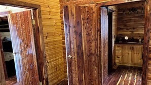 Ein Holzinterieur mit Küchenbereich, Holzvertäfelung und Holzdielen sowie einem Spülbecken mit Schränken.