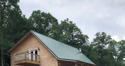 Cedar log cabin overlooking spring-fed ponds with waterfalls at Wautauga Springs