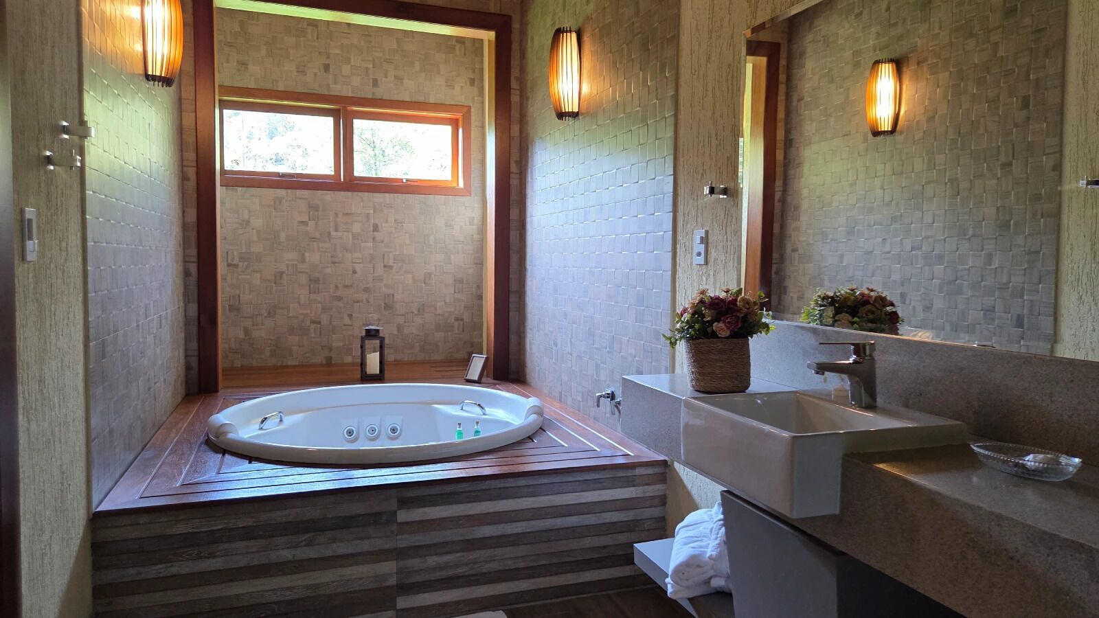 A modern bathroom with a freestanding bathtub, a large mirror, and a wooden vanity.