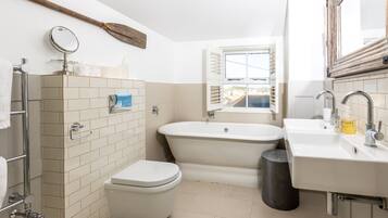 A bathroom with a toilet, bathtub, and sink.