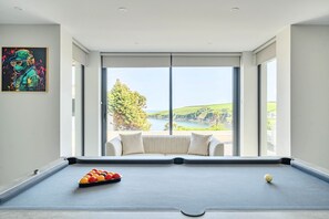 Una mesa de billar con vistas panorámicas, un cuadro en la pared y un sofá.