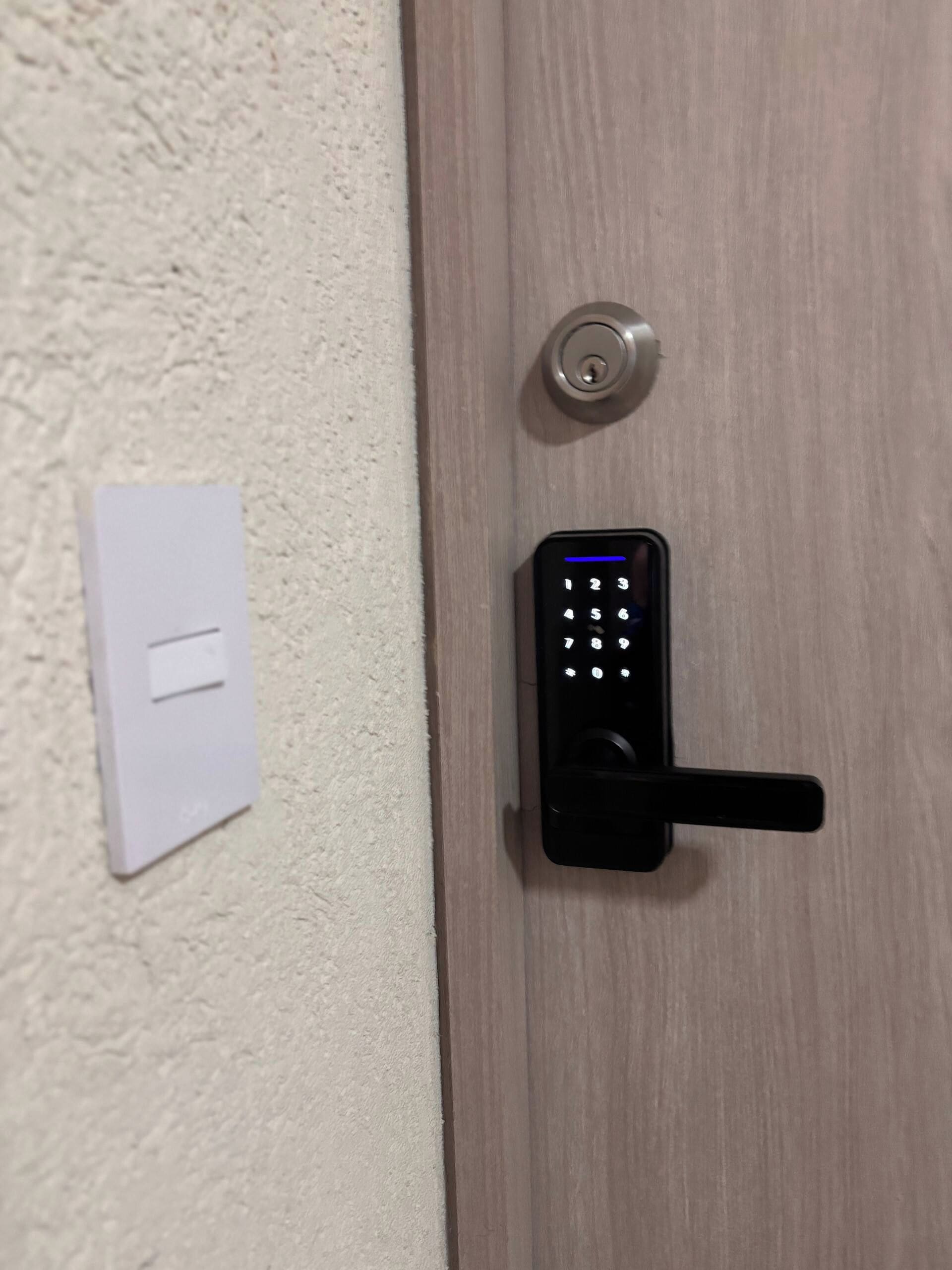 Una puerta con un moderno teclado electrónico de acceso y un orificio para llave.