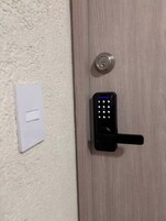 Una puerta con un moderno teclado electrónico de acceso y un orificio para llave.