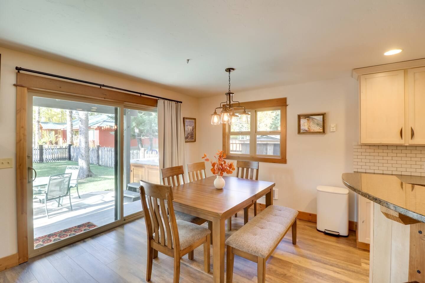 Dining area with a wooden table, bench, and sliding doors to the outdoor deck.