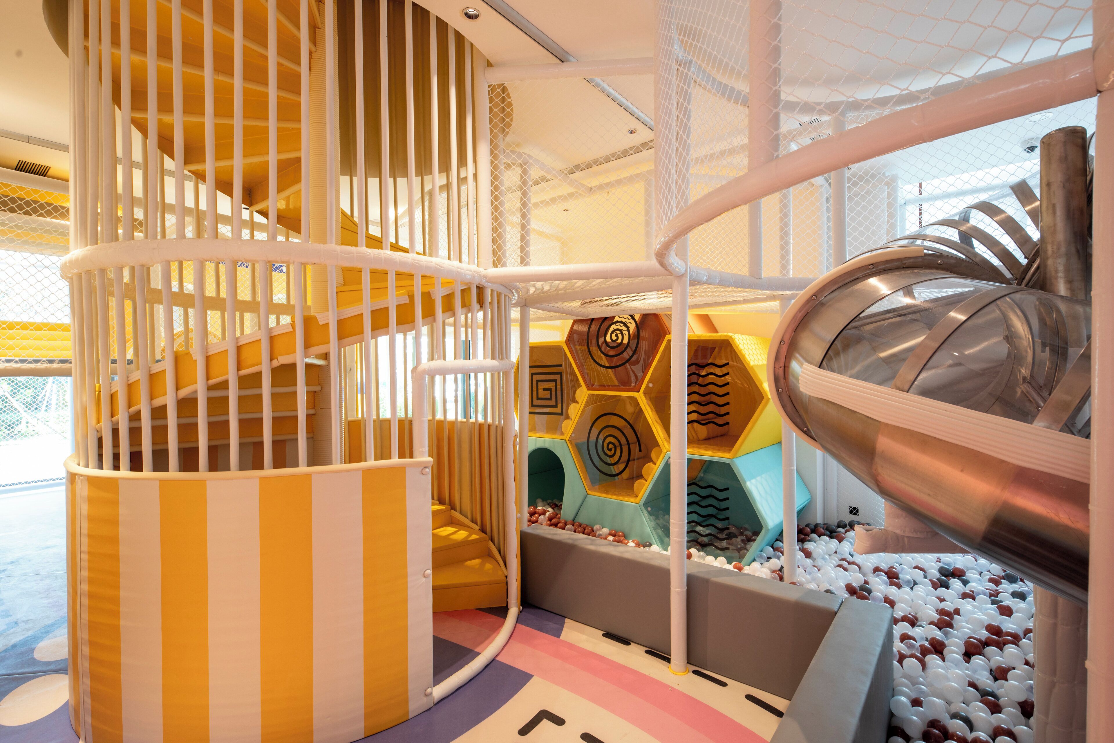 A children's play area with a spiral slide, a climbing structure, and a ball pit.