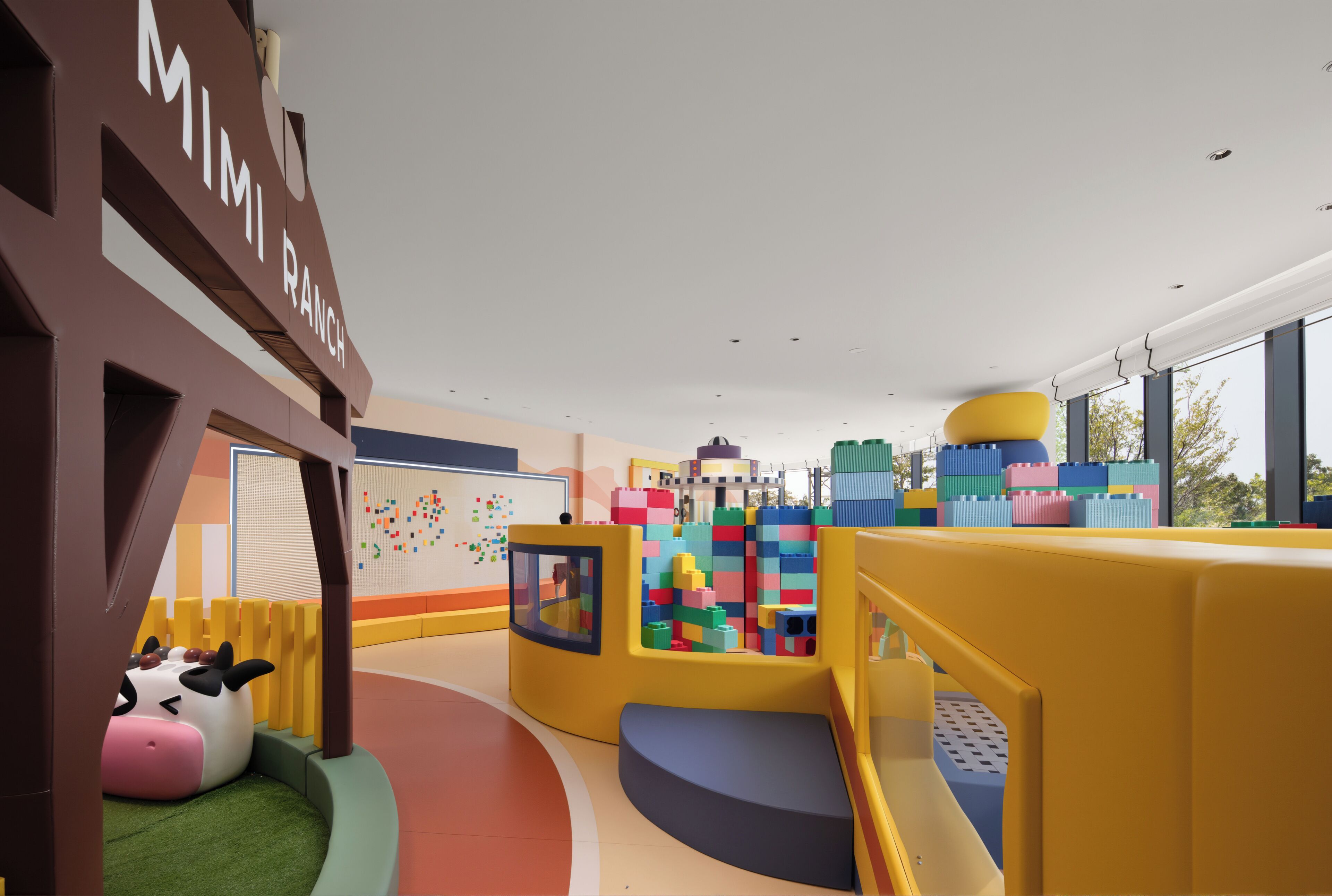 A children's play area with colorful building blocks, a slide, and a cow-shaped play structure.
