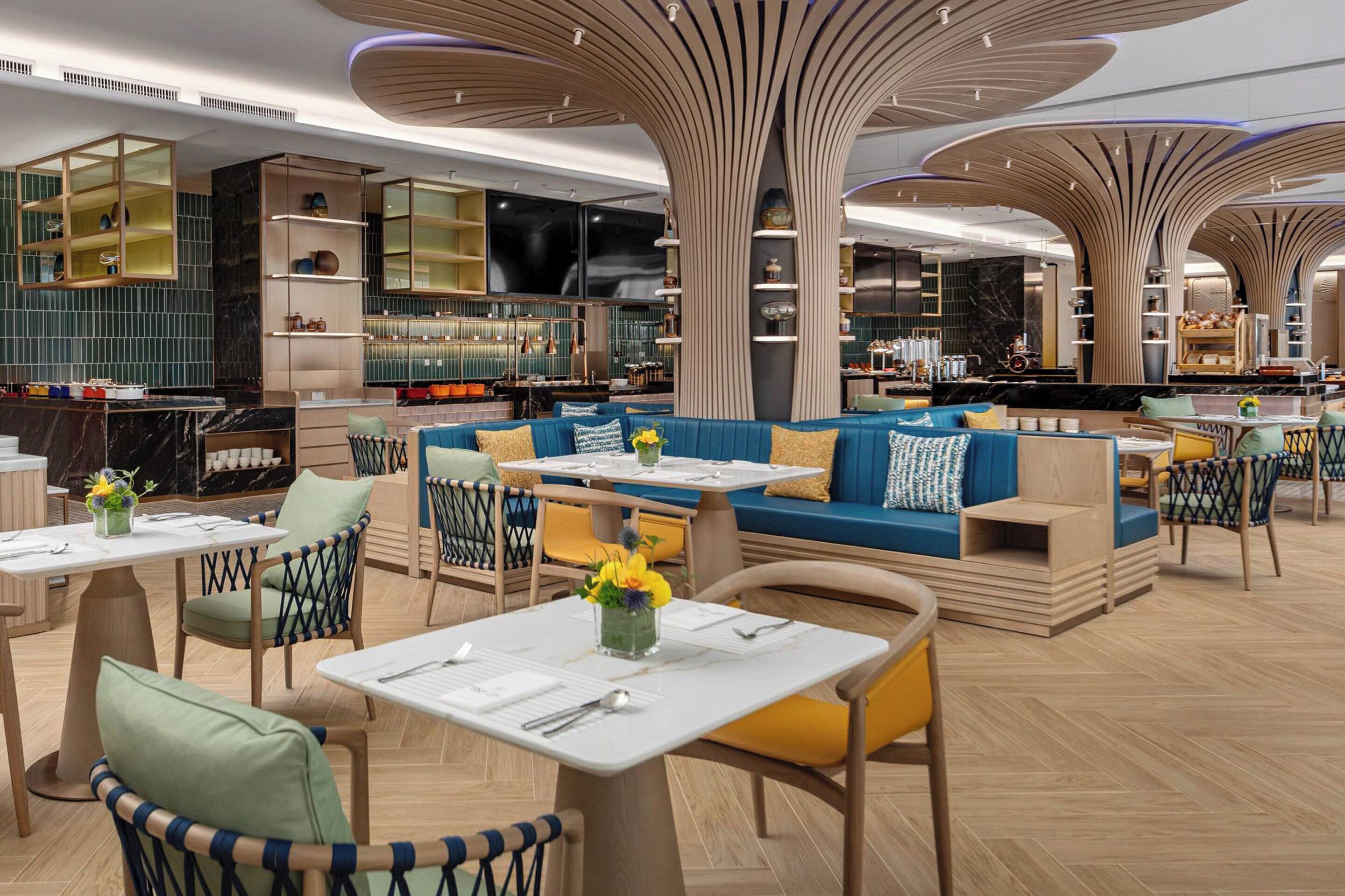 A modern restaurant with high ceilings, unique lighting fixtures, and a mix of seating options including tables and sofas.
