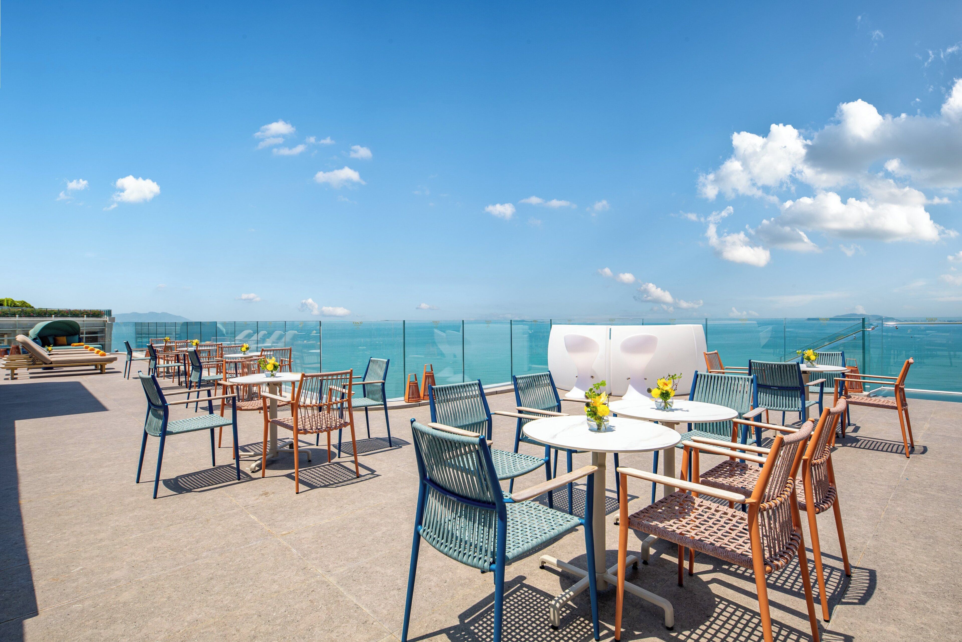 Terraço no terraço com área de estar externa, piscina e vista ampla do mar.