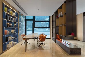 A modern library with bookshelves, a table, and chairs. - Holiday Inn Express Huangshan Mountain South Gate By Ihg (Huangshan)