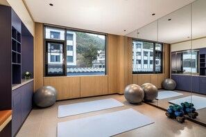 A modern fitness room with large windows, exercise balls, and yoga mats. - Holiday Inn Express Huangshan Mountain South Gate By Ihg (Huangshan)