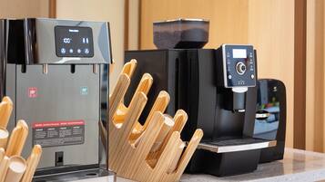 Eine Kaffeemaschine und ein Reiskocher stehen auf einer Küchenarbeitsfläche.