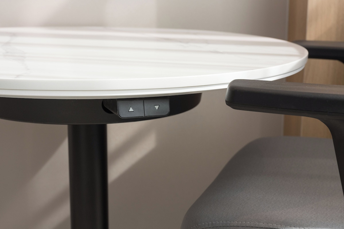 A round table with a white surface and a black base.