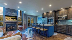 Una cocina moderna con armarios de madera oscura, electrodomésticos de acero inoxidable y un salpicadero azul.