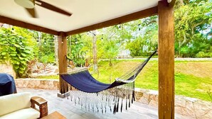 A hammock under a wooden pergola with a view of a lush garden. - Deluxe Modern Condo, with Cenote on Site.
24/7 security
5' walk to beach (Playa del Carmen)