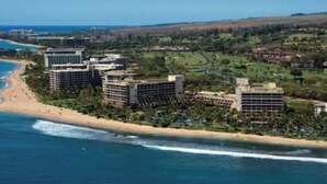 A coastal resort with beachfront villas, a sandy beach, and ocean views.