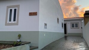 Une rue étroite bordée de deux bâtiments blancs, dont l’un porte une enseigne indiquant « Casa da Avo Lu ».