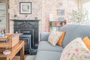 Ein gemütliches Wohnzimmer mit Kamin, einer Couch und einem Bücherregal.