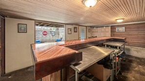 Un restaurante con una barra larga, techo de madera e iluminación de estilo industrial.