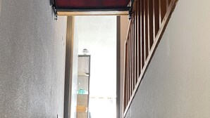A staircase with a red canopy at the top, leading to a room with a window and a door. - Studio at the foot of the slopes - La Mongie (Bagnères-de-Bigorre)