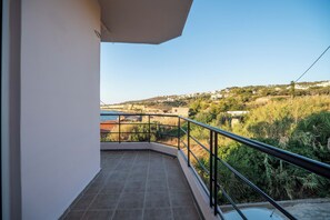 A balcony with a view of a hillside town. - SEA GEM APARTMETS steps from the sand (Chania)