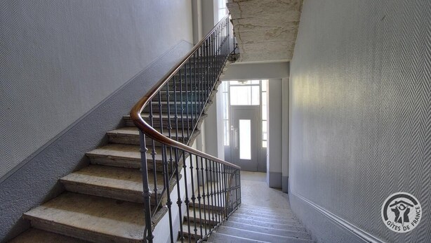 Eine Treppe mit Metallgeländer, die zu einer Tür führt.