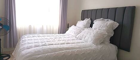 Tabla de planchar con plancha, acceso a internet y ropa de cama