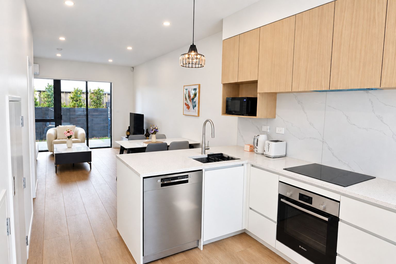A modern kitchen with a dishwasher, microwave, toaster, and oven.