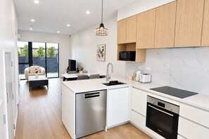 A modern kitchen with a dishwasher, microwave, toaster, and oven.