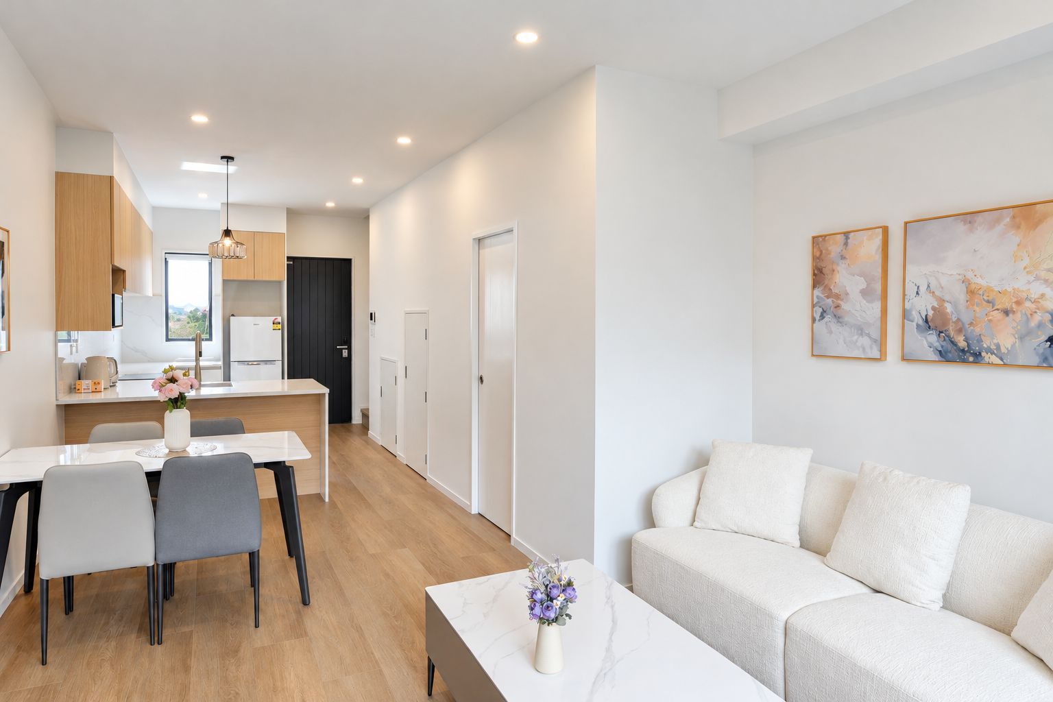 A modern apartment with a dining area, kitchen, and living room.