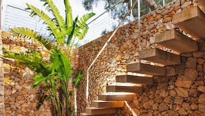 A stone staircase with a handrail, surrounded by greenery and a stone wall. - Modern 2-unit villa with heated pool and seaview (Leuca)