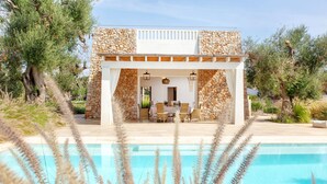 A poolside area with a stone building, outdoor seating, and a clear view of the pool. - Modern 2-unit villa with heated pool and seaview (Leuca)