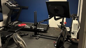Gimnàs amb equip d'exercici, incloent una cinta de córrer, una bicicleta estatica i una banca de peses.